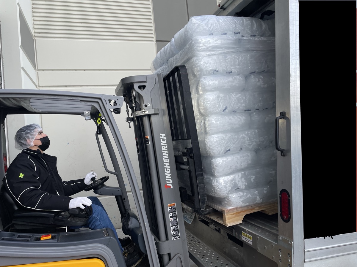 Forklift loading pallets of bagged ice